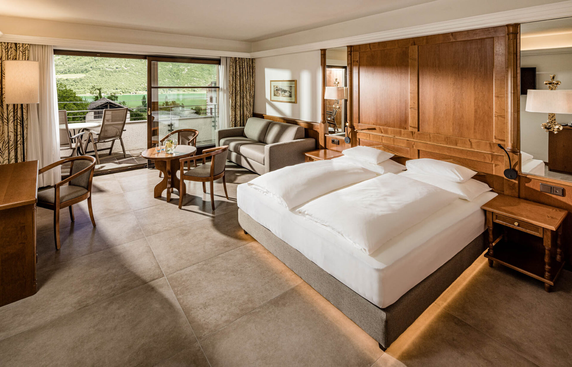 Zimmer 'Weinberg' im Hotel Haus am Hang: Doppelbett, Holzpaneel, Sitzbereich und große Fenster mit Blick ins Grüne.